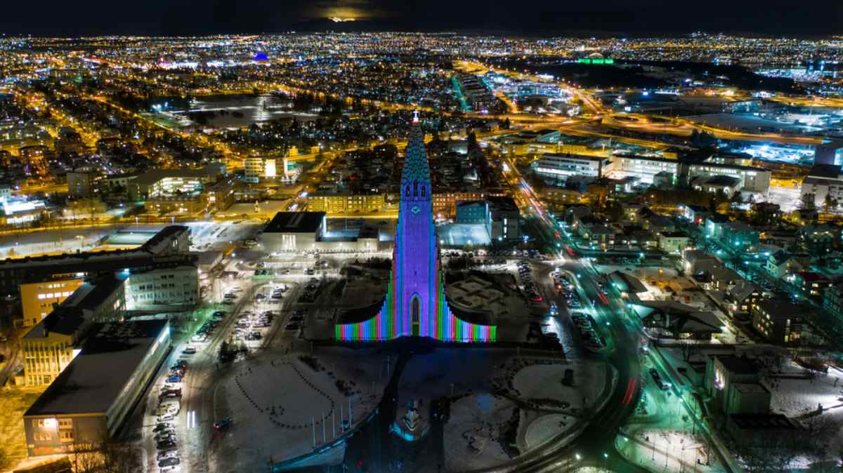 Vista de dron de la ciudad de Reikiavik durante la noche en lo que parece la proyecci&oacute;n de las luces del festival Winter Lights Festival sobre la catedral de Hallgr&iacute;mskirkja.