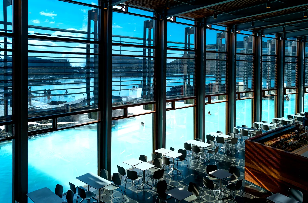 Cena con vistas en el restaurante Blue Lagoon Interior del restaurante Blue Lagoon, con grandes ventanales que ofrecen una vista de las humeantes piscinas geotermales.