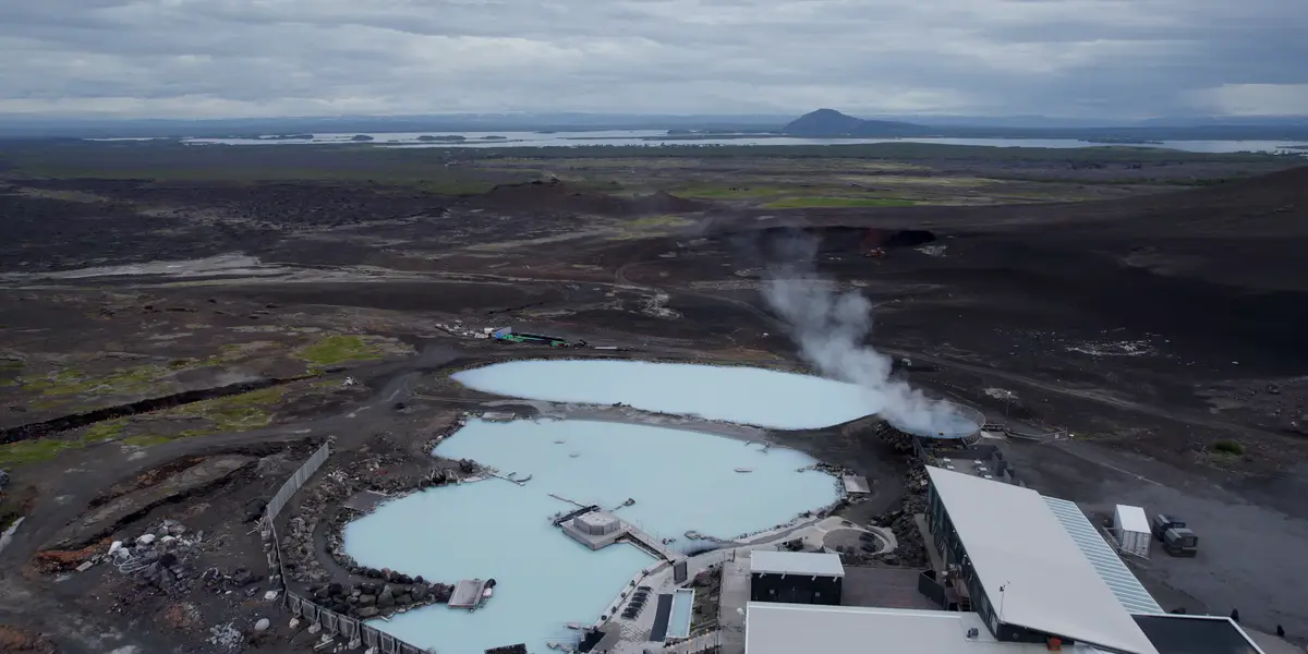 Vista aérea de los baños naturales de Mývatn en Islandia, rodeados de un paisaje volcánico con aguas geotermales de color azul lechoso. Una parada perfecta para relajarse en un viaje en autocaravana.