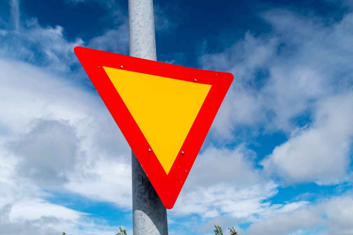 Una se&ntilde;al de tr&aacute;fico islandesa triangular invertida indica que el veh&iacute;culo debe ceder el paso en la carretera.